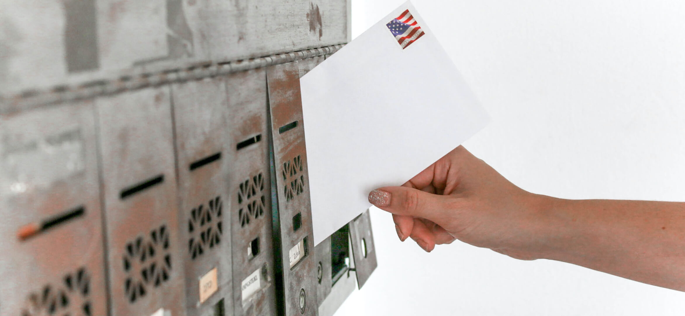 Mailman putting mail in a mailbox.