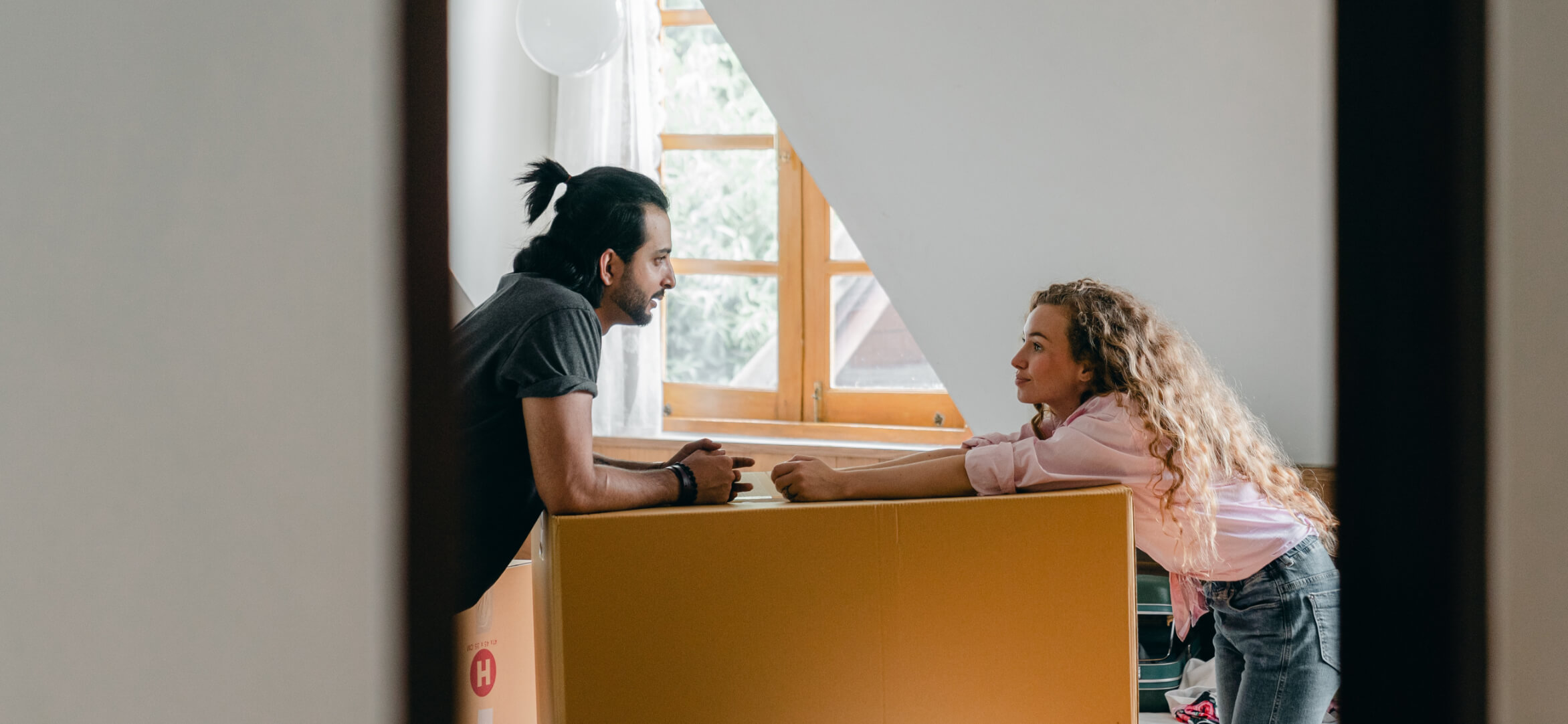 Two people moving cardboard boxes.